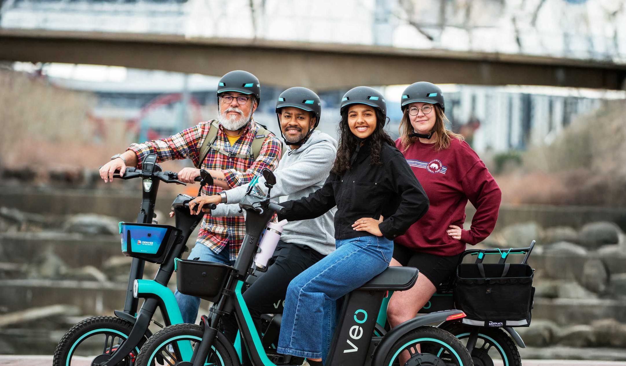 A group of people sitting on standing and seated scooters looking at the camera